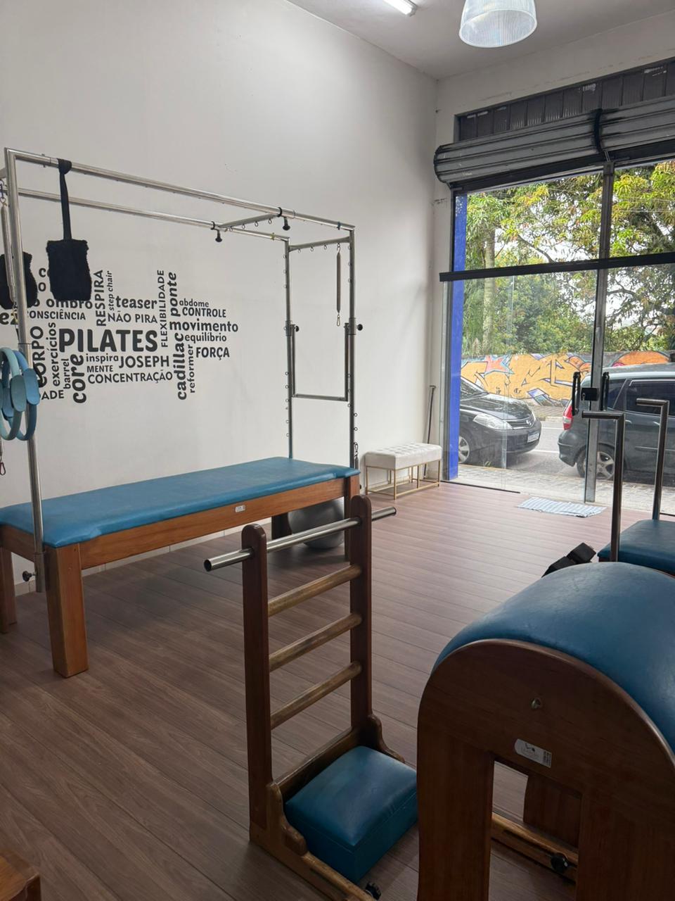 Sala do estúdio com parede Florence, cadeiras e aparelhos de pilates